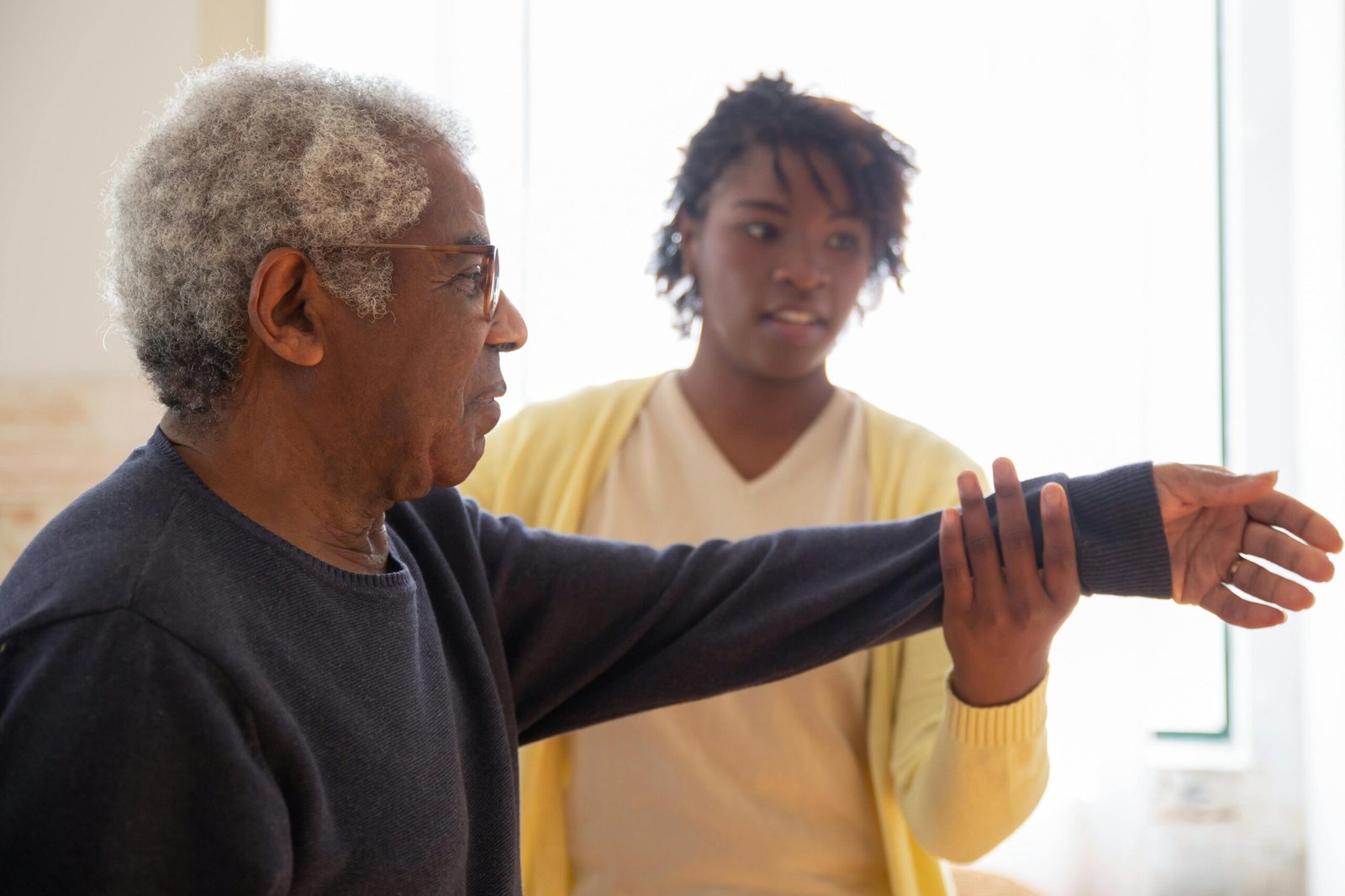 Care giver helping patient with arm raises exercise